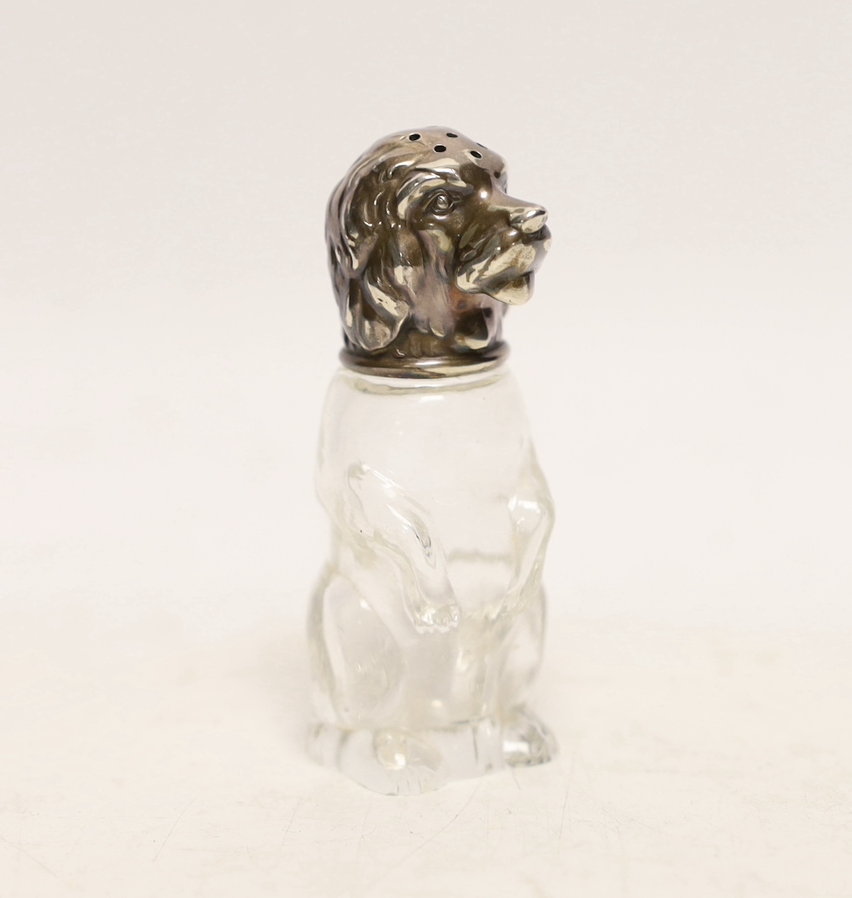 A continental novelty 900 standard white metal mounted glass pepperette, with dog's head cap, maker M&M, height 72mm.